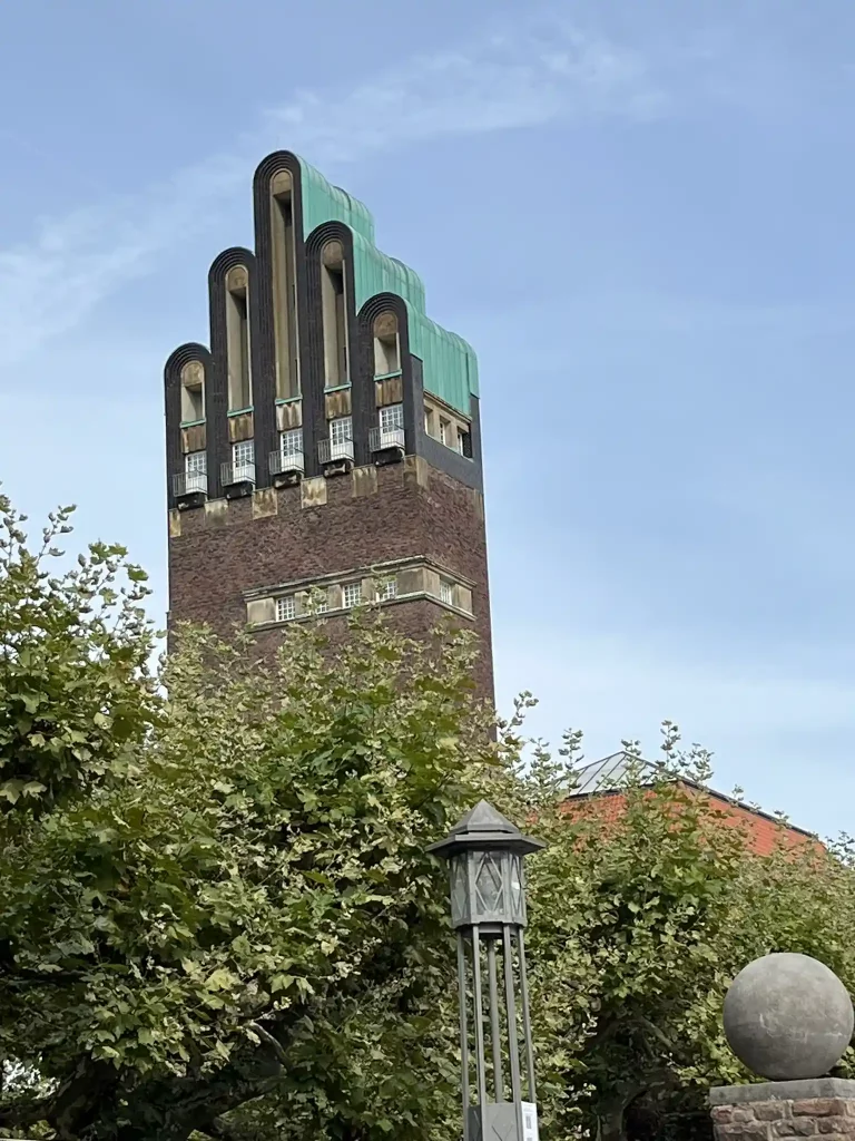 Der Hochzeitsturm in Darmstadt, auch bekannt als „Fünf-Finger-Turm“, ragt über die Bäume der Mathildenhöhe und ist ein Wahrzeichen des Jugendstils.