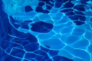 Wasseroberfläche mit Lichtreflexionen in leuchtendem Blau